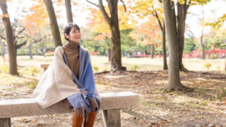 公園でロングブーツを履く女性