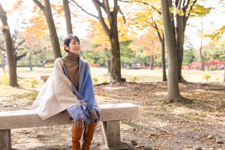公園でロングブーツを履く女性