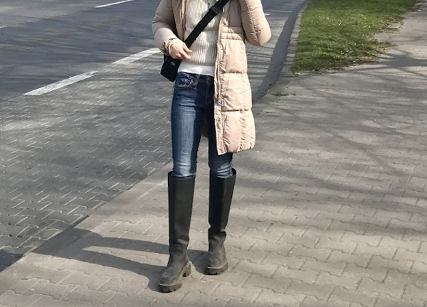 ロングブーツを履いて歩く女性